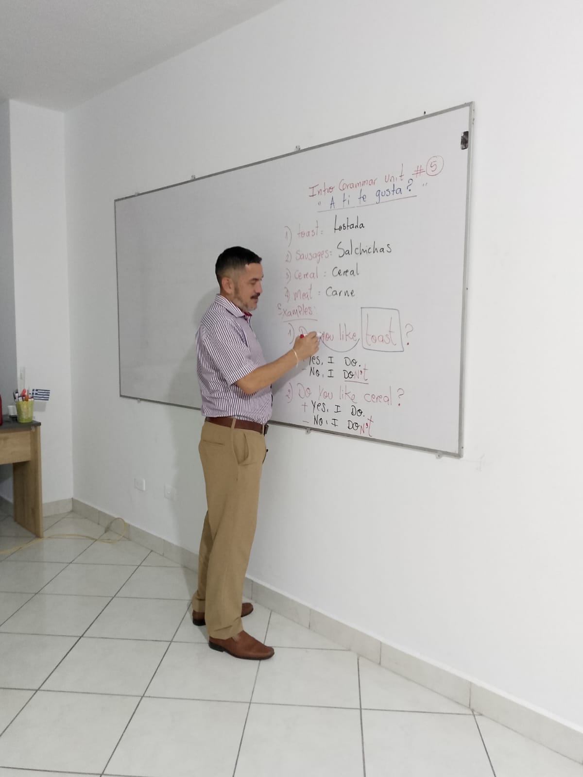 Teacher Jackson Lima ensenando ingles en pizarra